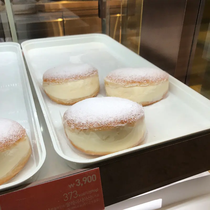 뽀얀 슈가파우더가 뿌려진 우유크림 도넛