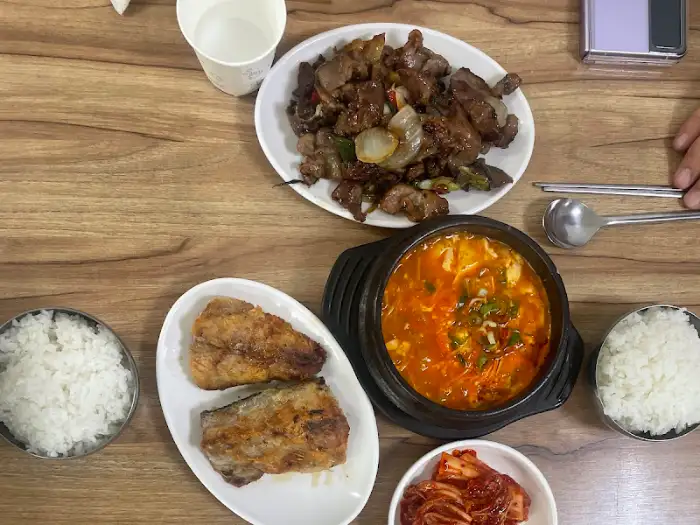 제육볶음, 순두부찌개, 밥, 김치가 차려진 한상차림