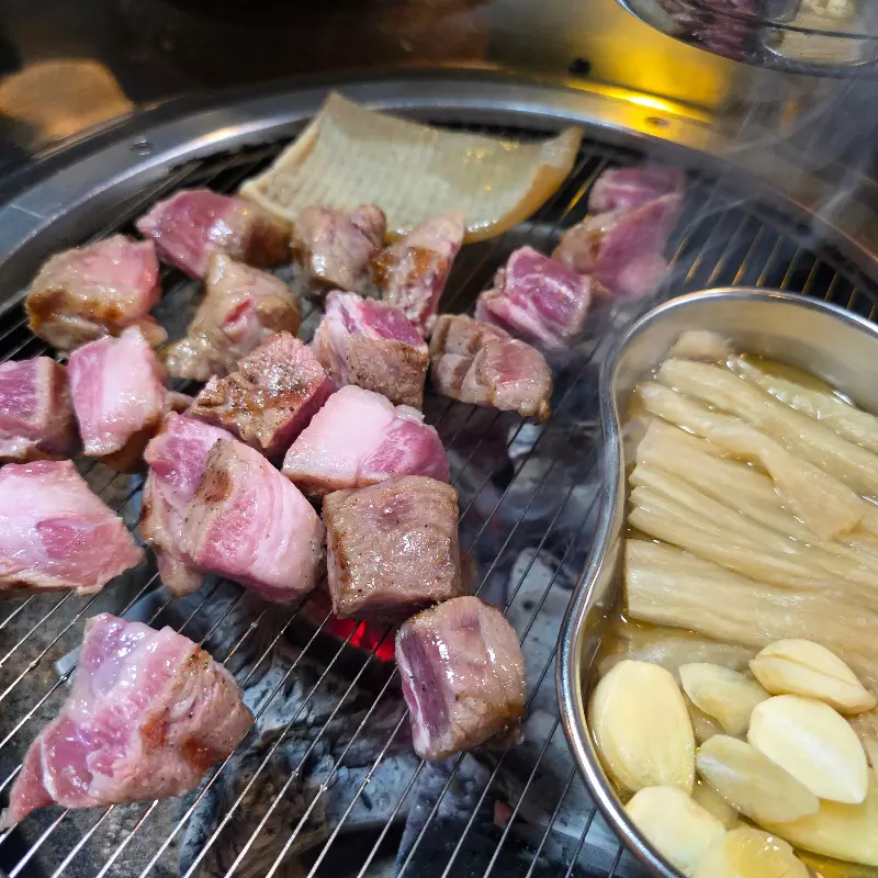 숯불 위에서 익어가는 고기와 껍데기