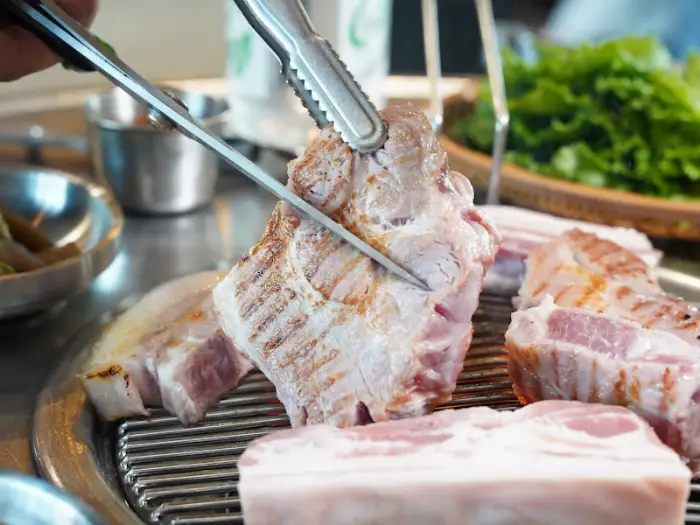 직원이 흑돼지 구워주는 모습