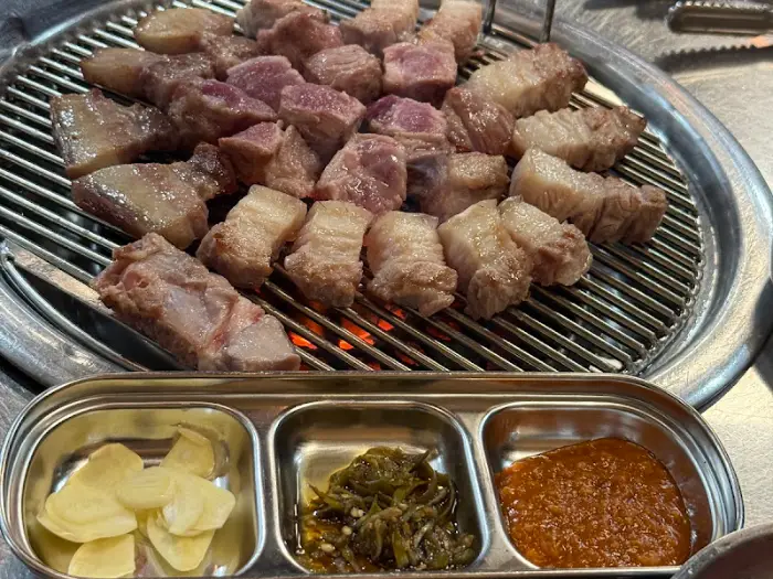 구워진 흑돼지 조각과 곁들임 소스