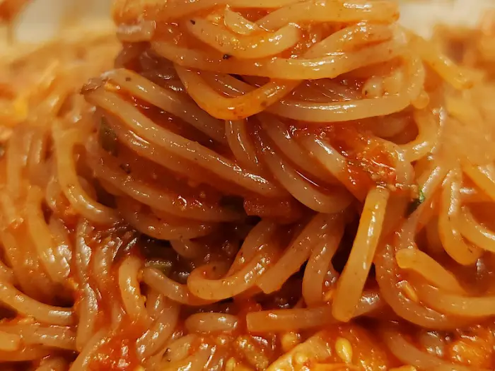 비빔냉면의 면발이 빨간 양념에 버무려져 있다.