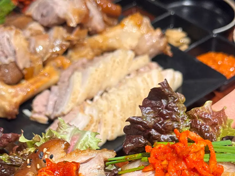 상추쌈에 족발, 보쌈, 김치를 얹어 한 입 가득