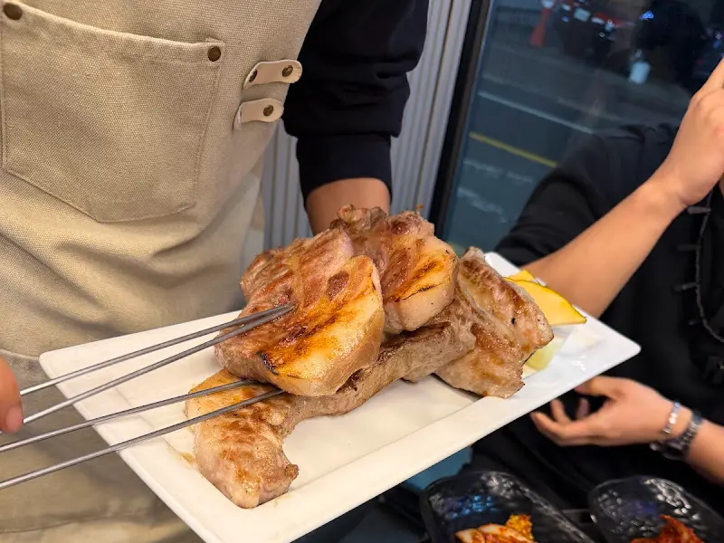 초벌된 흑돼지를 직원이 테이블로 가져다 주는 모습