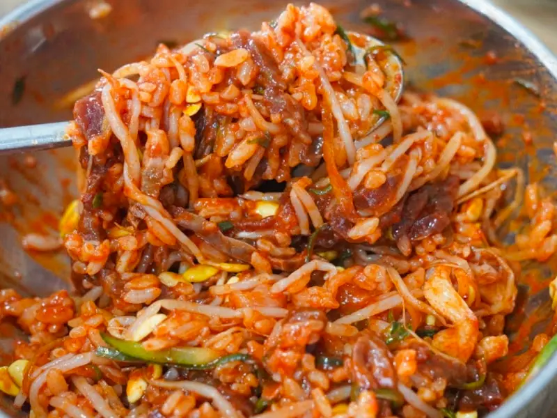 육회비빔밥을 수저로 크게 들어올린 모습