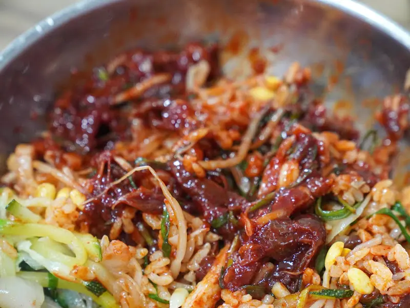 비빔밥 안의 다양한 야채와 육회 고명
