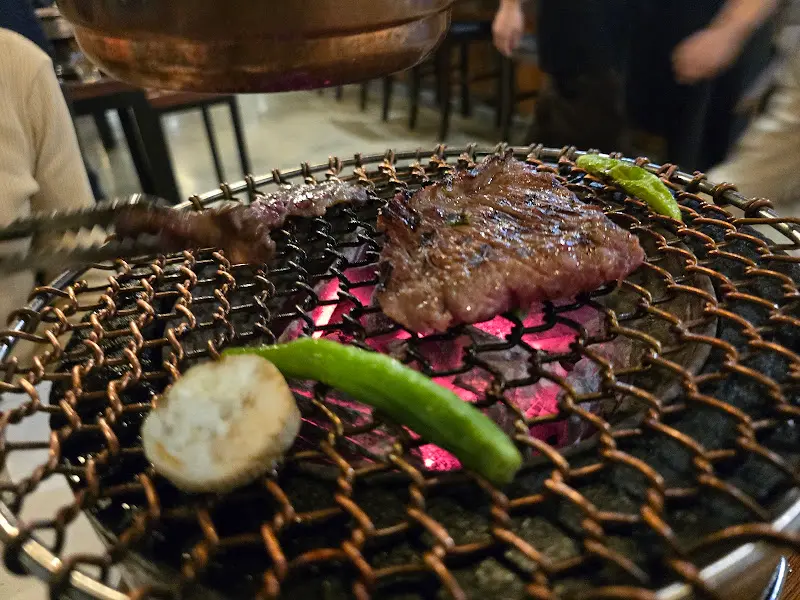 숯불 위에서 구워지는 한우와 채소