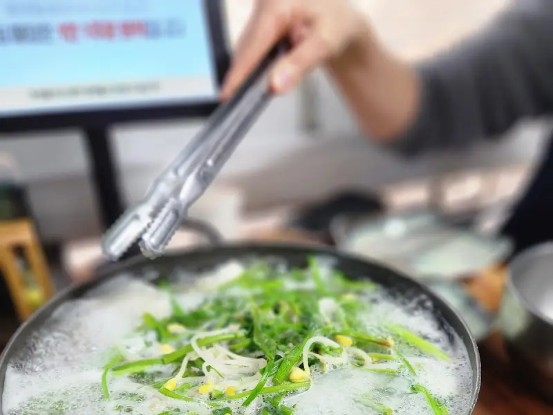 복칼국수에 미나리를 넣는 모습