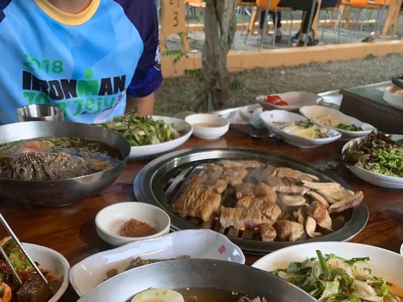 테이블 위에 차려진 물냉면, 갈비, 쌈 채소 등