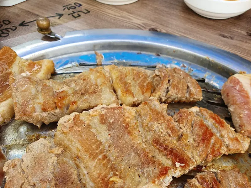 불판 위에서 노릇하게 구워지고 있는 돼지갈비