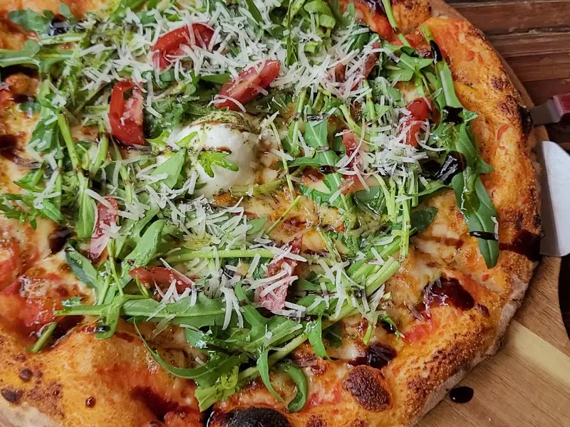 루꼴라 베네 부라타 피자의 전체적인 모습. 토마토도 보인다.