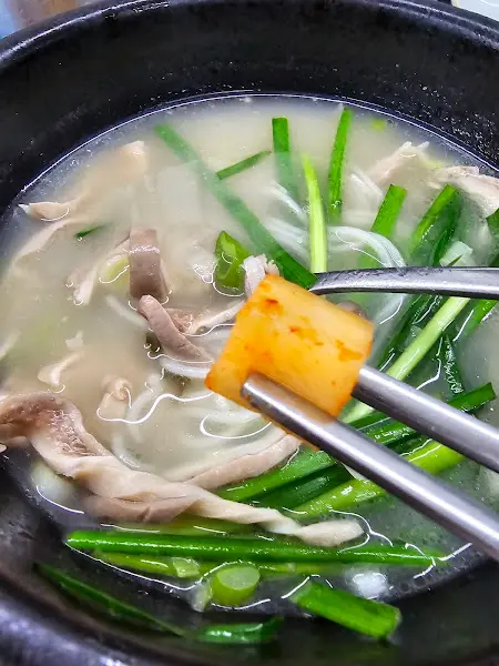 돼지국밥에 김치를 올려 먹는 모습