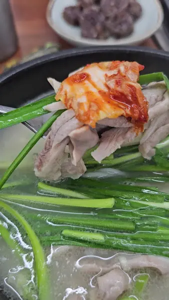 돼지국밥에 김치를 올려 먹는 모습