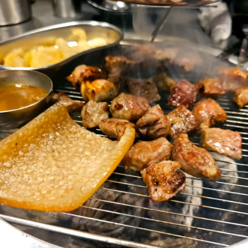 숯불 위에서 껍데기와 함께 익어가는 고기