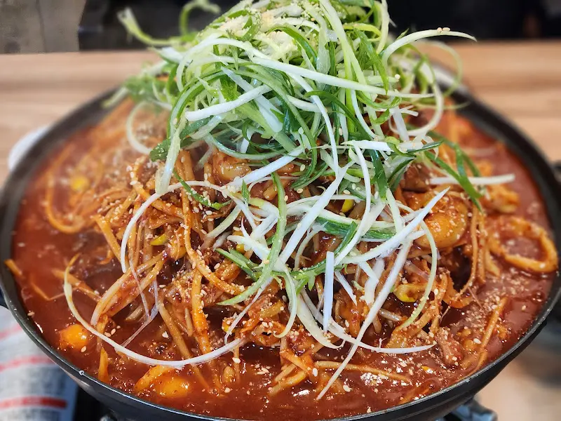 매운 뼈찜의 모습. 빨간 양념과 채 썬 파가 듬뿍 올려져 있다.