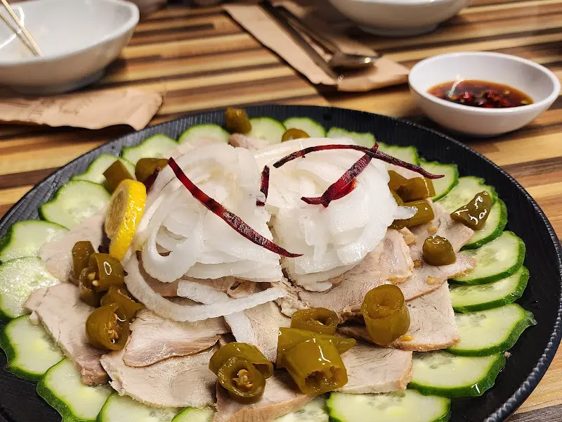 장육 접시를 위에서 찍은 사진으로, 오이, 양파, 고추 등이 고기와 함께 담겨 있는 모습