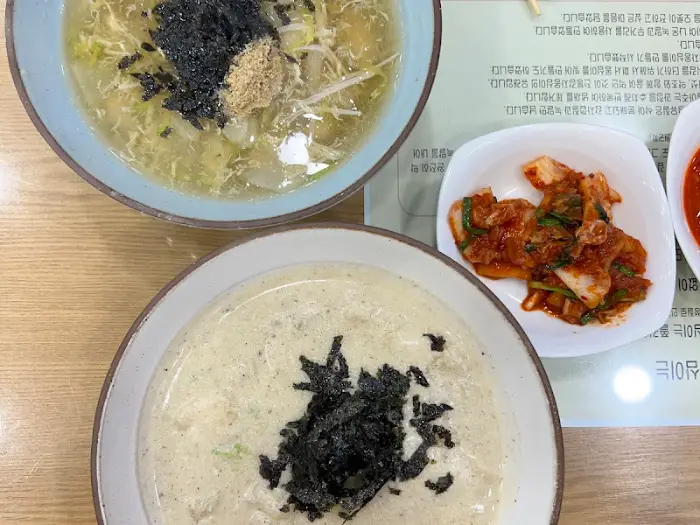 두 개의 옹심이 그릇이 테이블 위에 놓여있다. 한 그릇은 맑은 국물, 다른 한 그릇은 하얀 들깨 국물이다.