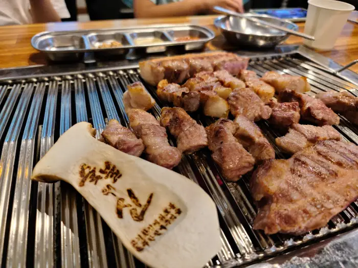 두툼한 삼겹살과 버섯이 숯불 위에서 익어가는 모습