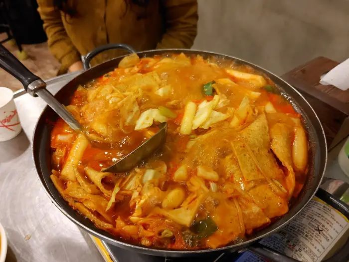 떡볶이 냄비에 국자를 이용해 떠내는 모습