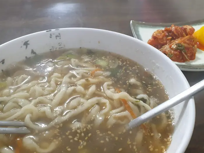 칼국수 위로 김가루와 깨가 뿌려진 모습