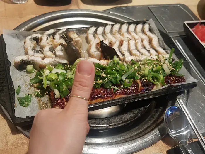 엄지 척을 하며 장어구이를 보여주는 모습