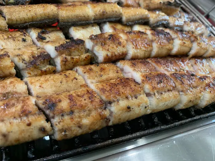 그릴 위 노릇하게 구워지고 있는 통통한 장어 토막들