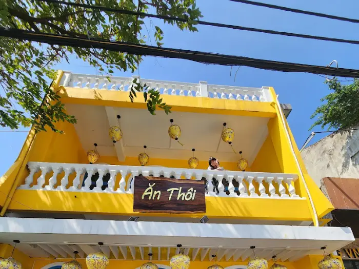 노란색 건물과 야외 장식이 돋보이는 식당 외관