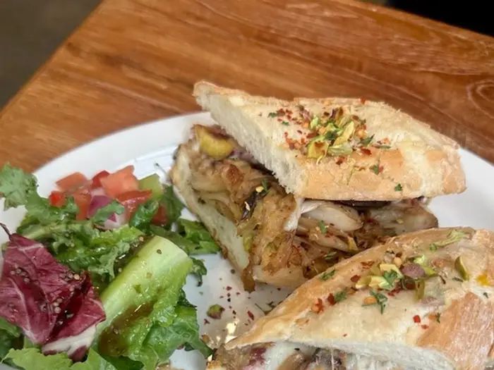 반으로 나뉜 샌드위치와 곁들여 나온 신선한 샐러드