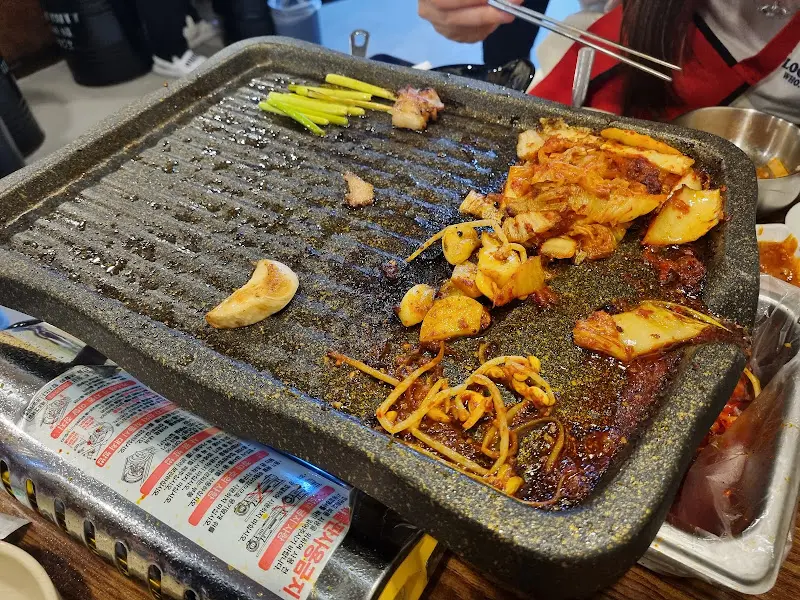 불판 위의 삼겹살과 김치