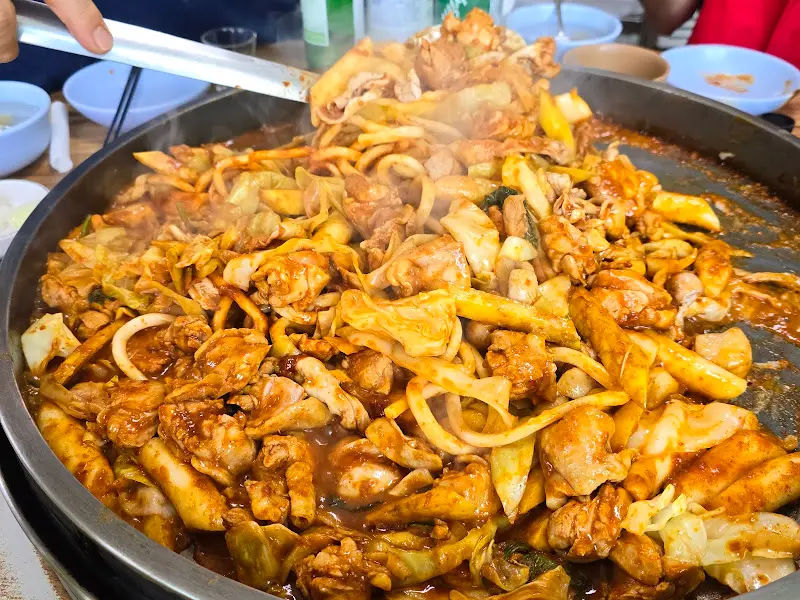 닭갈비에 우동사리를 추가하여 볶는 모습