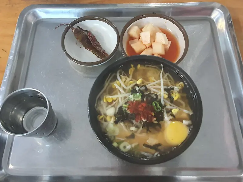 콩나물국밥과 깍두기, 고추장아찌가 쟁반에 담겨 있는 모습