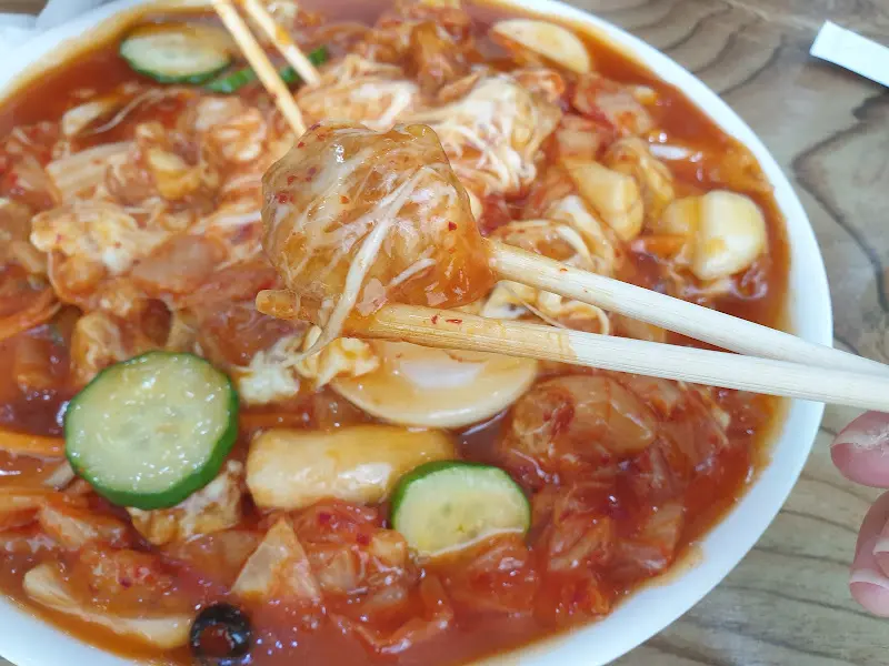 젓가락으로 김치치즈탕수육을 집는 모습