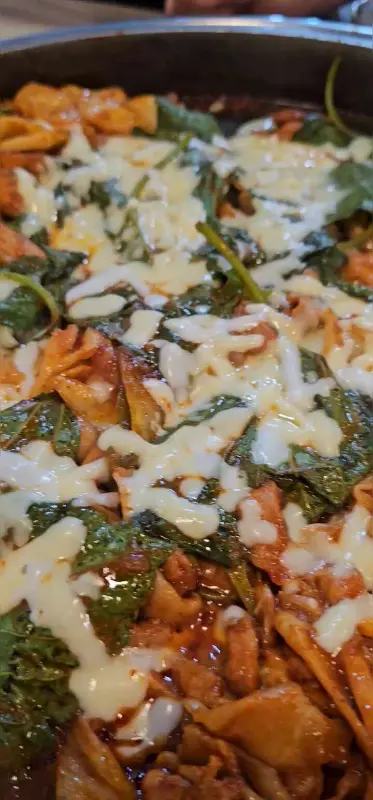 모짜렐라 치즈와 깻잎이 닭갈비 위에 토핑된 클로즈업 샷