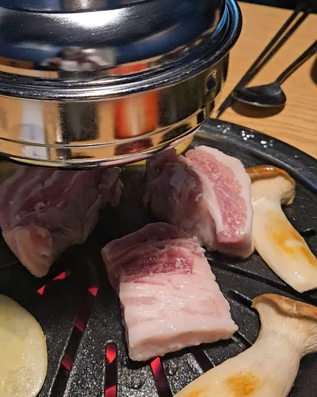 불판 위에서 익어가는 두툼한 삼겹살