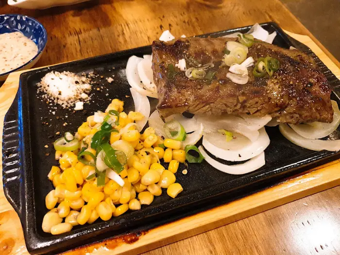 철판에 담긴 스테이크와 옥수수