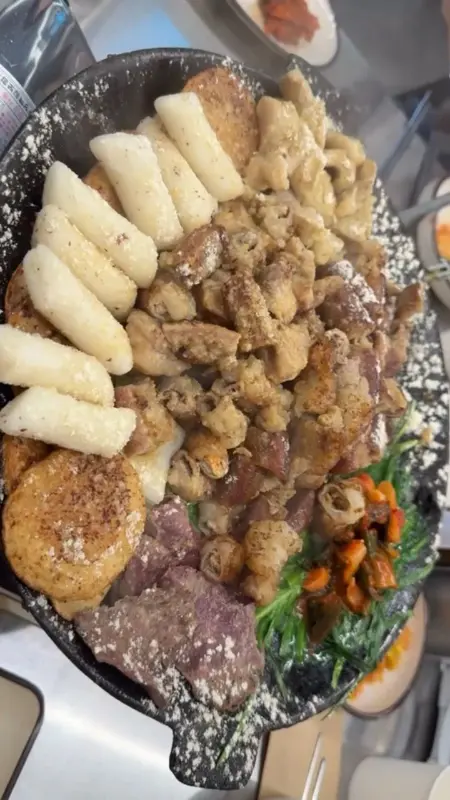 불판 가득 채운 곱창, 떡, 감자, 염통 구이