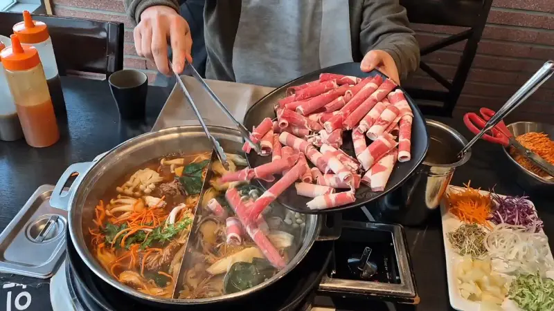 샤브샤브 냄비에 고기를 넣는 모습