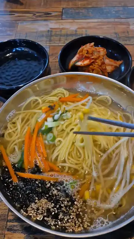 고기 국수 면발을 젓가락으로 집어올리는 모습