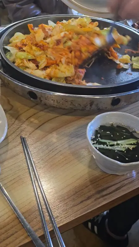 닭갈비 철판 옆에 놓인 미역 오이냉국의 모습