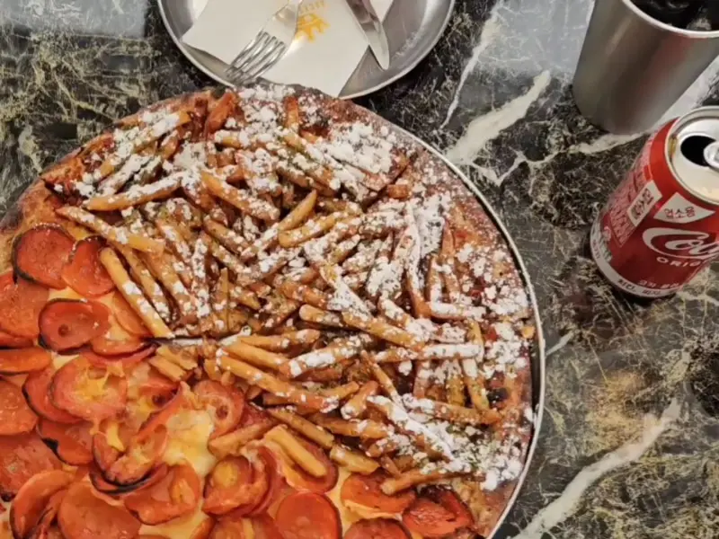 감자튀김 위에 슈가파우더가 뿌려진 포테이토 피자