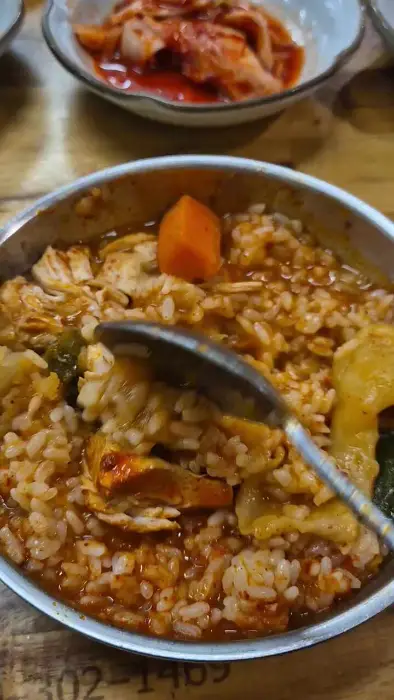 밥 위에 오징어볶음 비벼 먹는 모습