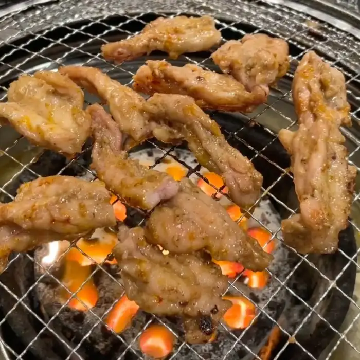숯불 위에서 익어가는 닭고기 조각들