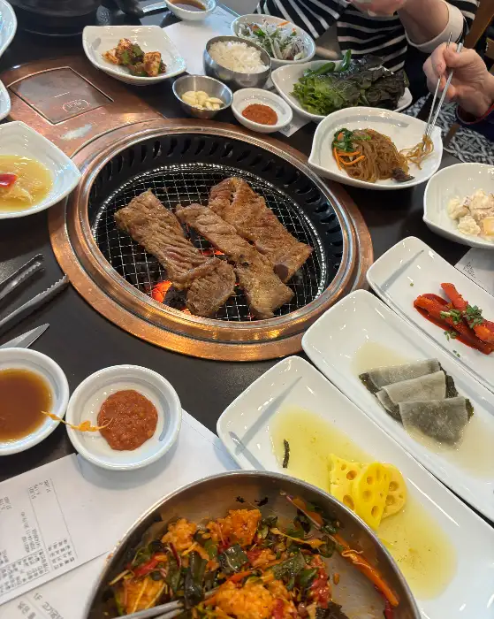 다양한 고기 메뉴와 반찬이 풍성하게 차려진 테이블