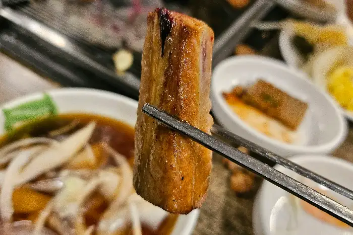 집게로 잡고 있는 갈비 조각