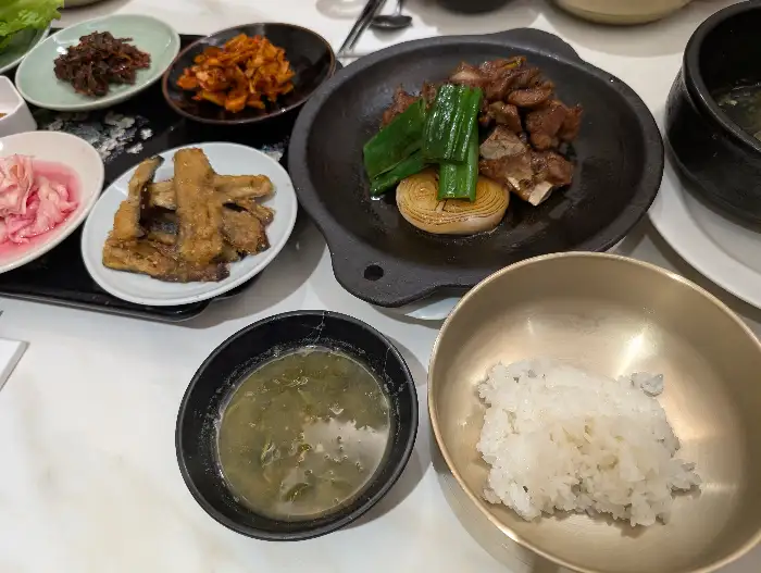 가지 튀김과 양념된 고기, 신선한 쌈 채소가 준비되어 있다.