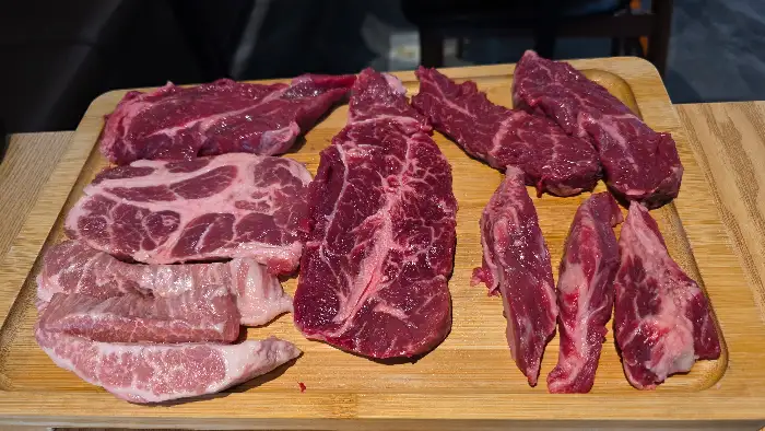 나무 도마 위에 다양하게 플레이팅된 신선한 소고기 모듬