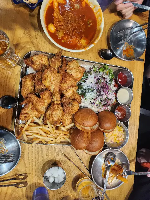 치킨, 쫄면, 샐러드가 한 상에 차려진 모습