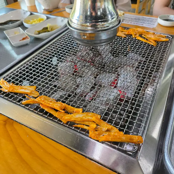 장어구이 옆에 함께 구워지고 있는 파채 무침
