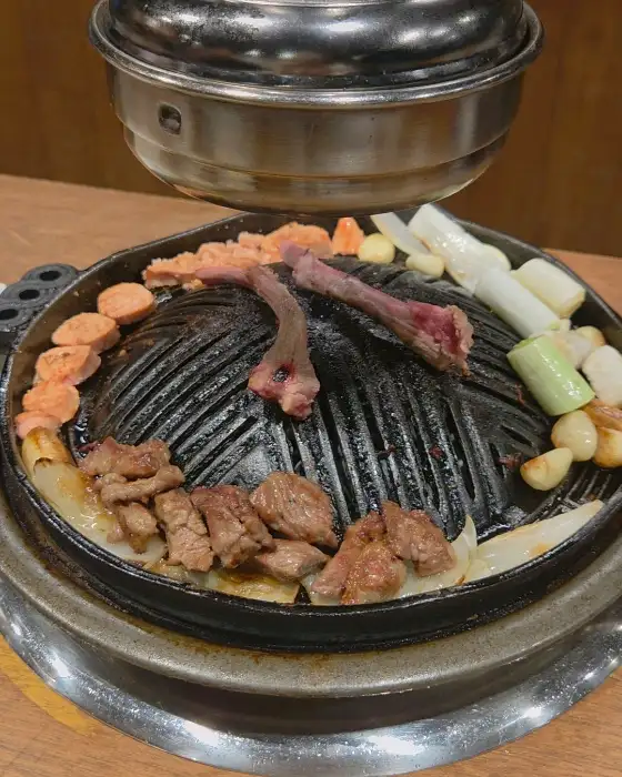 숯불 위에서 익어가는 양갈비와 곁들임 야채들.