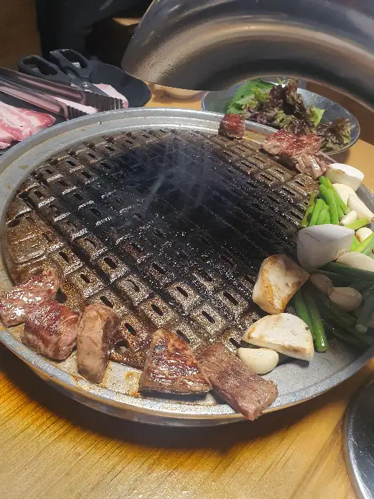 시원하고 먹음직스러운 김치말이 국수 한 그릇. 얇게 썬 김치와 채소가 고명으로 올라가 있다.